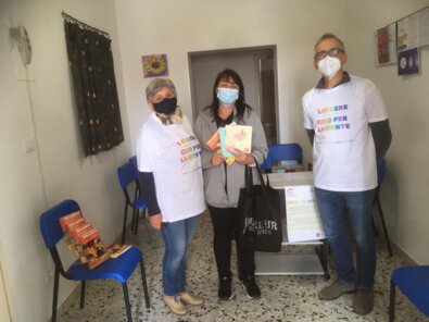 Volontari che accolgono una famiglia all’emporio della solidarietà